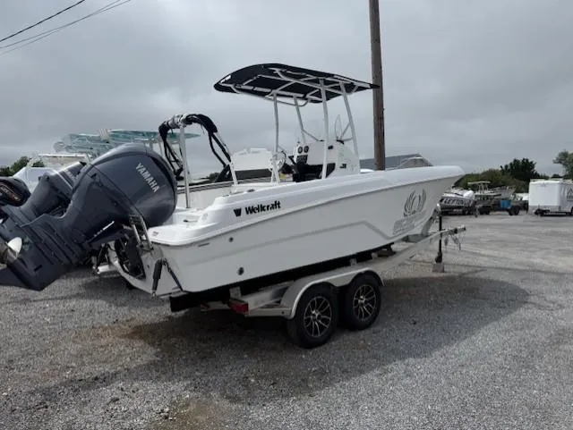 Slide: The Image of 2025 Wellcraft 202 Fisherman boat on trailer with Yamaha outboard motor, parked on gravel. - 2