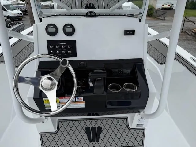 Slide: The Image of 2025 Wellcraft 202 Fisherman boat dashboard with steering wheel and control panel. - 5