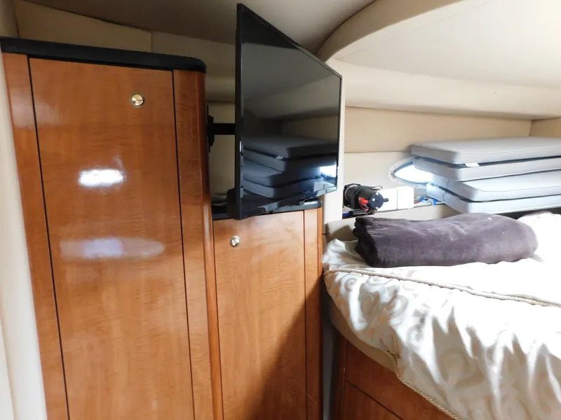 Slide: The Image of Interior of 2003 Maxum 3500 SY yacht with TV, wooden cabinets, and bed. - 22