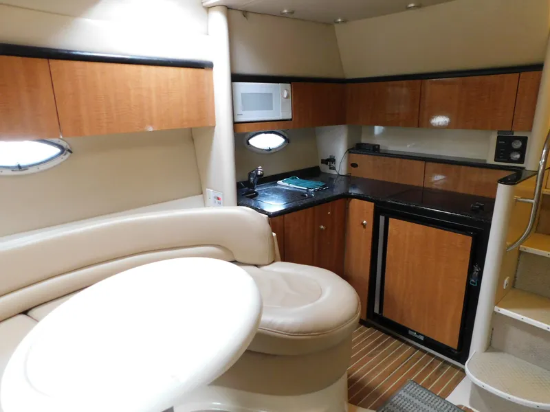Slide: The Image of 2003 Maxum 3500 SY yacht interior with kitchenette, seating, and stairs. - 23