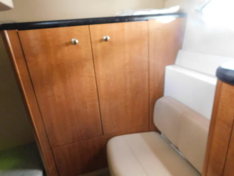 Slide: The Image of Interior of 2003 Maxum 3500 SY boat with wooden cabinets and cushioned seating. - 26