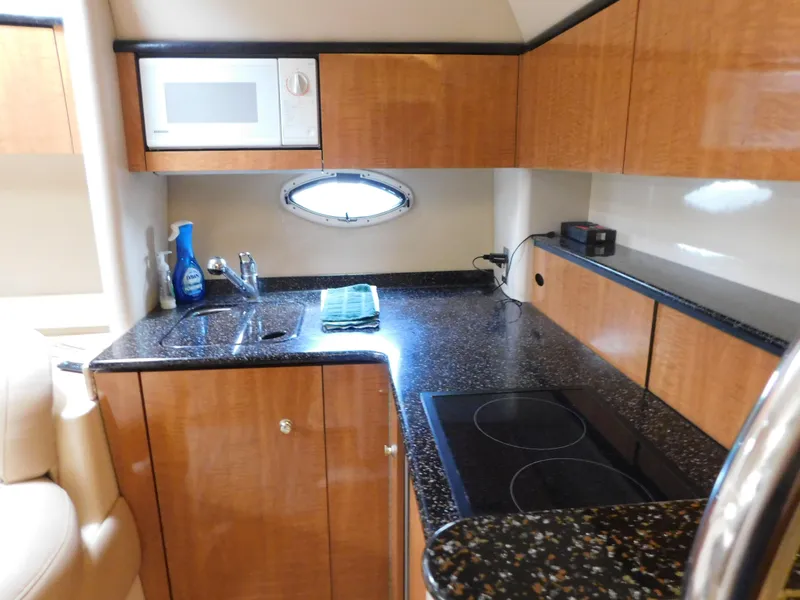 Slide: The Image of 2003 Maxum 3500 SY yacht kitchen with microwave, sink, and stovetop. - 29