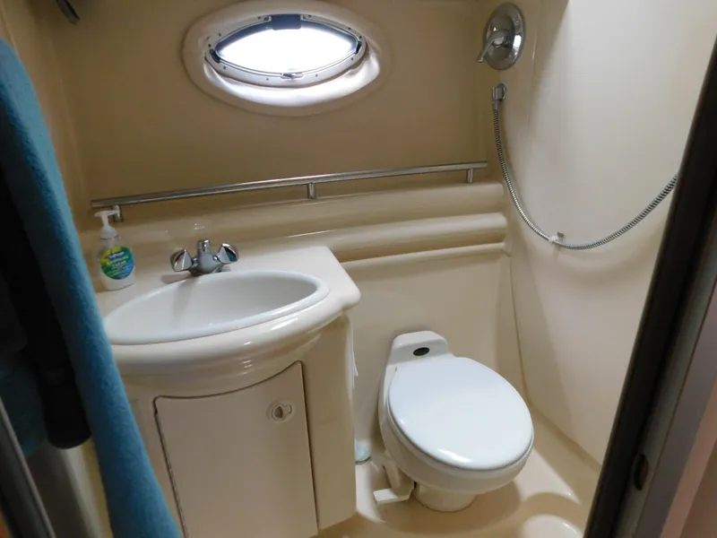 Slide: The Image of Compact bathroom in a 2003 Maxum 3500 SY boat, featuring sink, toilet, and shower. - 31