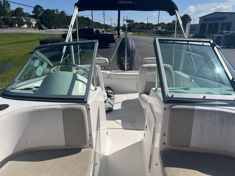 Slide: The Image of 2012 Pioneer 175 Venture boat interior with seating and windshield, parked outdoors. - 11