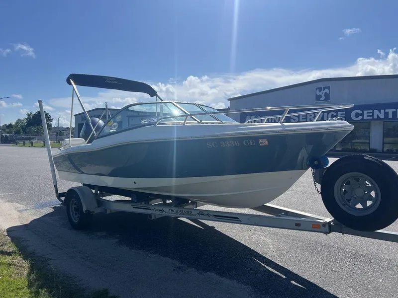 Slide: The Image of 2012 Pioneer 175 Venture boat on trailer, parked near a marine service center. - 6