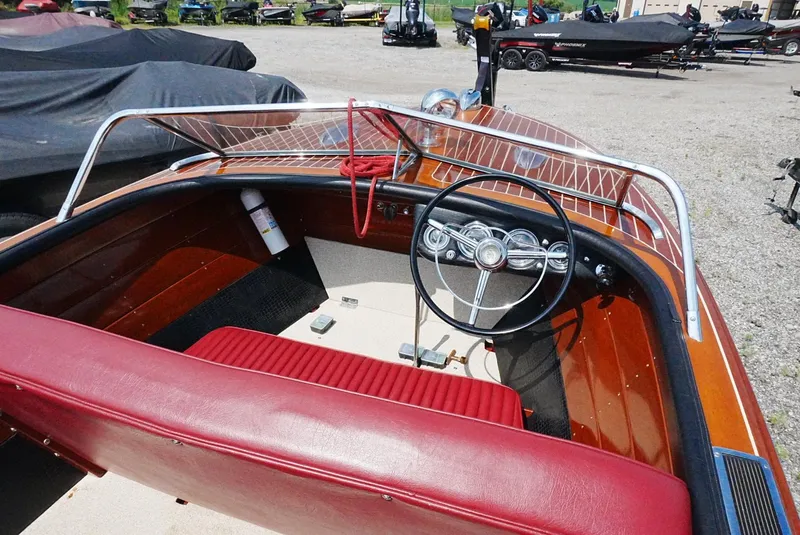 Slide: The Image of 1956 Chris-Craft Continental boat interior with red seating and classic steering wheel. - 10