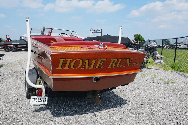 Slide: The Image of 1956 Chris-Craft Continental boat named "Home Run" on a trailer, parked outdoors. - 13