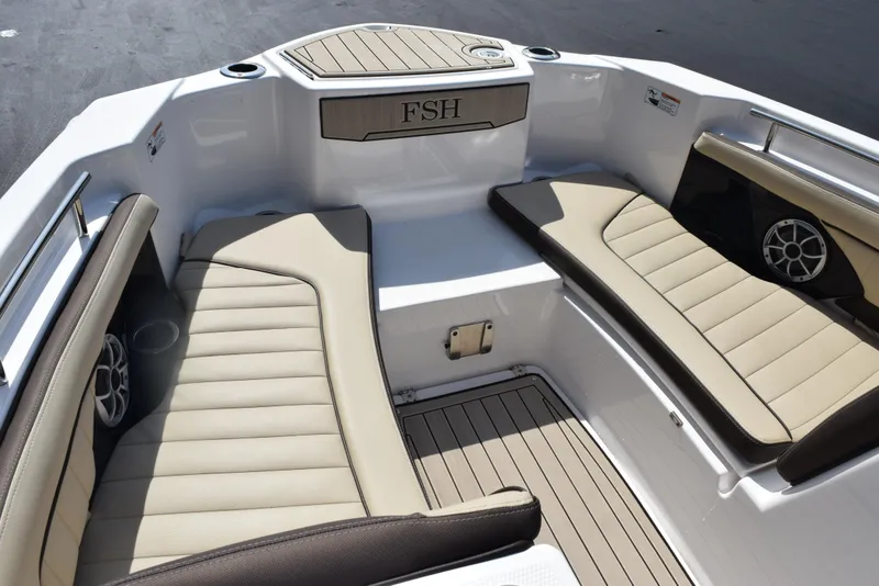Slide: The Image of 2024 Yamaha Boats 255 FSH Sport H interior with beige seating and speaker system. - 14