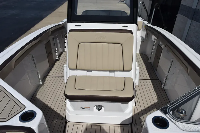 Slide: The Image of 2024 Yamaha Boats 255 FSH Sport H interior with beige seating and sleek design. - 15