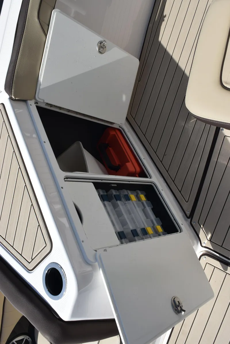 Slide: The Image of 2024 Yamaha Boats 255 FSH Sport H storage compartments with fishing gear and accessories. - 18