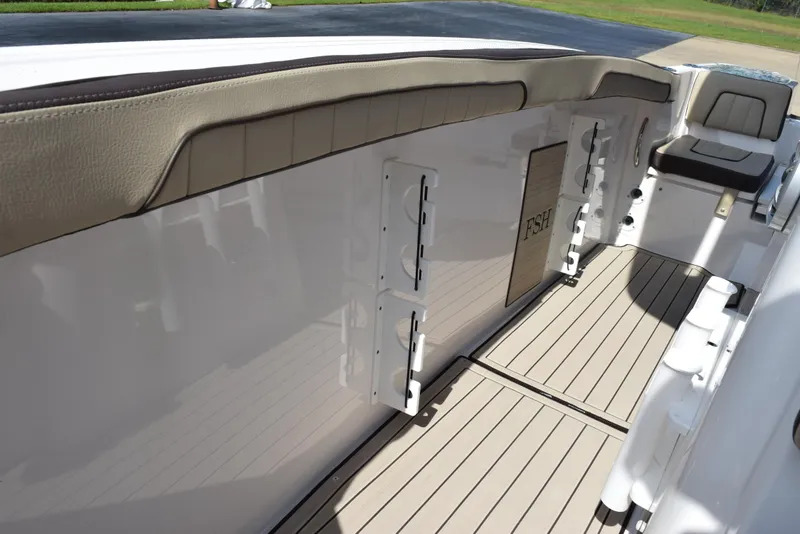 Slide: The Image of 2024 Yamaha Boats 255 FSH Sport H interior with cushioned seating and sleek flooring. - 19
