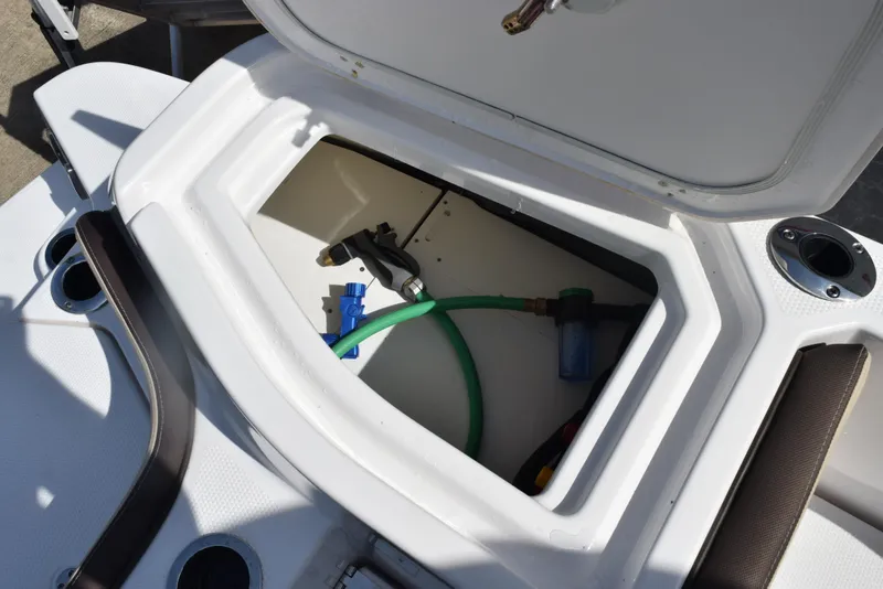 Slide: The Image of 2024 Yamaha Boats 255 FSH Sport H storage compartment with hose and fittings. - 25