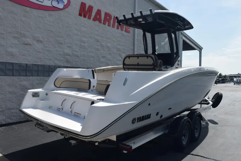 Slide: The Image of 2024 Yamaha Boats 255 FSH Sport H on trailer, displayed outside marine dealership. - 4