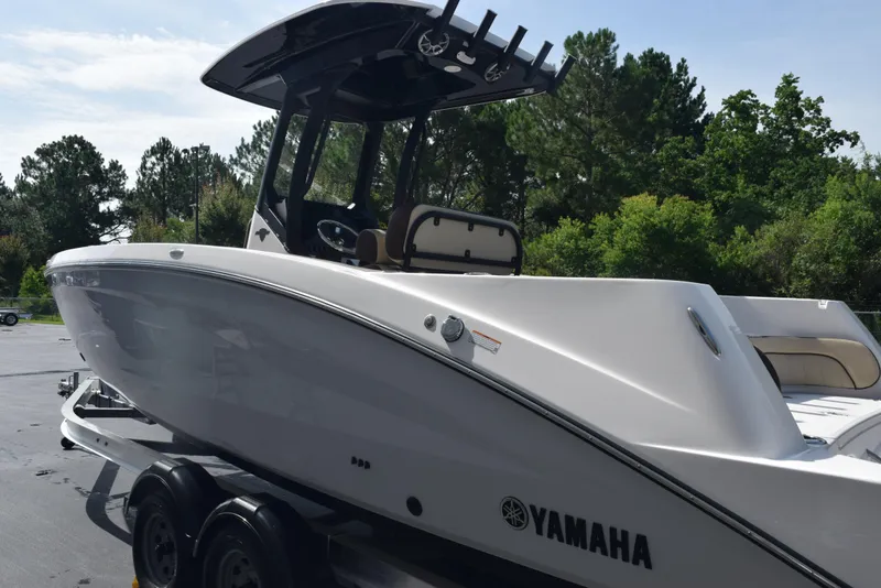 Slide: The Image of 2024 Yamaha Boats 255 FSH Sport H on trailer, surrounded by trees. - 6