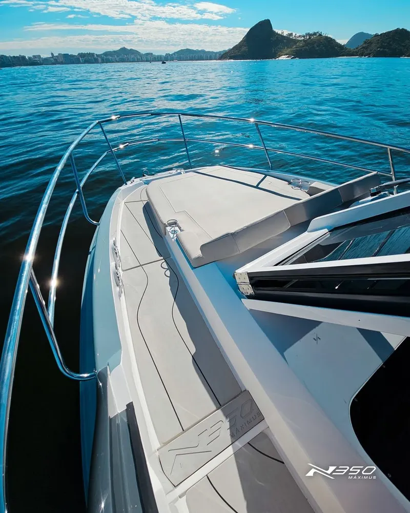 Slide: The Image of 2025 NX Boats NX350 on water, featuring sleek deck design and scenic coastal backdrop. - 5
