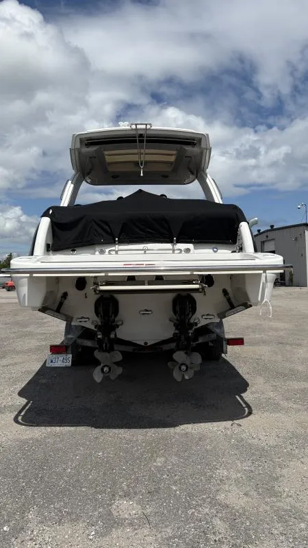 Slide: The Image of 2022 Formula 350 CBR boat, rear view, parked on gravel under cloudy sky. - 14