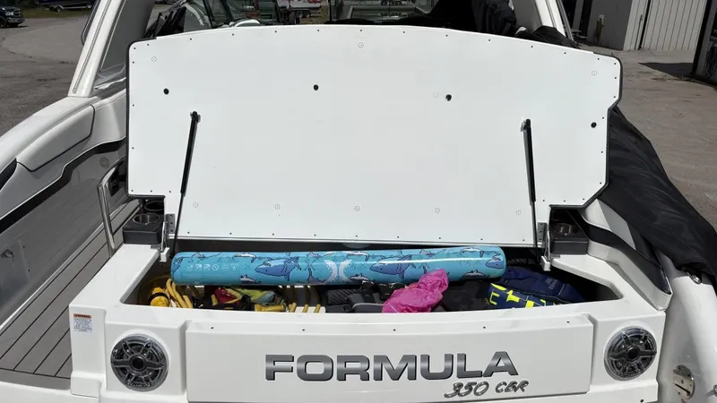 Slide: The Image of 2022 Formula 350 CBR boat storage compartment open, revealing various items inside. - 24