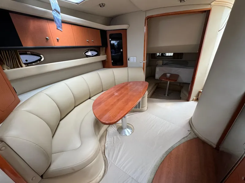 Slide: The Image of Interior of 2005 Chaparral Signature 350 yacht with beige seating and wooden table. - 11
