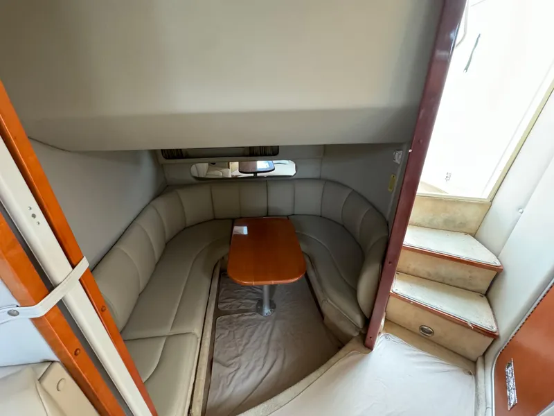 Slide: The Image of 2005 Chaparral Signature 350 cabin interior with curved seating and wooden table. - 13