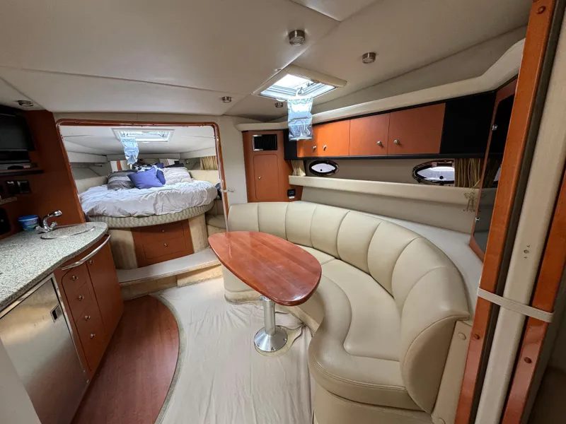 Slide: The Image of 2005 Chaparral Signature 350 interior with cozy seating, bed, and kitchenette. - 9