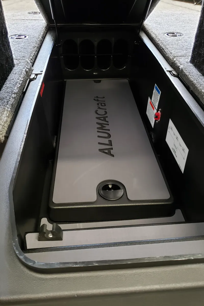 Slide: The Image of 2025 Alumacraft Competitor 175X Sport storage compartment with branded lid and organized interior. - 12