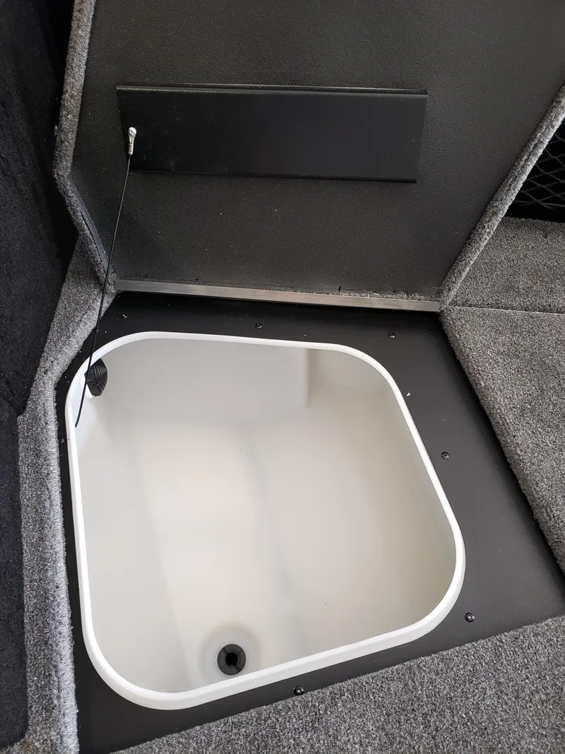 Slide: The Image of 2025 Alumacraft Competitor 175X Sport boat storage compartment, open and empty. - 13