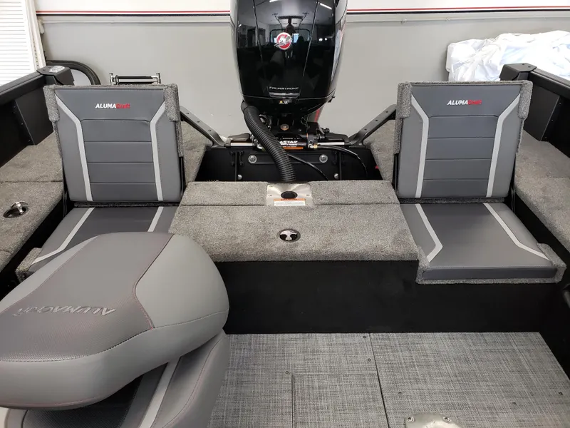 Slide: The Image of 2025 Alumacraft Competitor 175X Sport boat interior with gray seating and motor. - 16