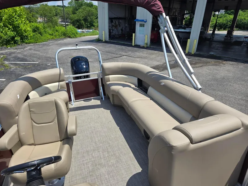 Slide: The Image of 2026 Starcraft LX20R pontoon boat with beige seating, steering wheel, and outdoor setting. - 10
