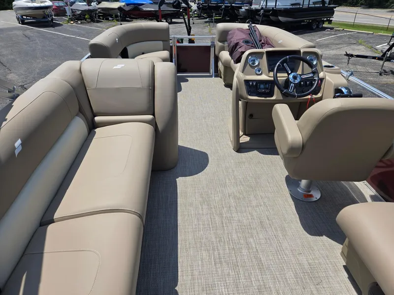 Slide: The Image of 2026 Starcraft LX20R pontoon boat interior with beige seating and steering console. - 7