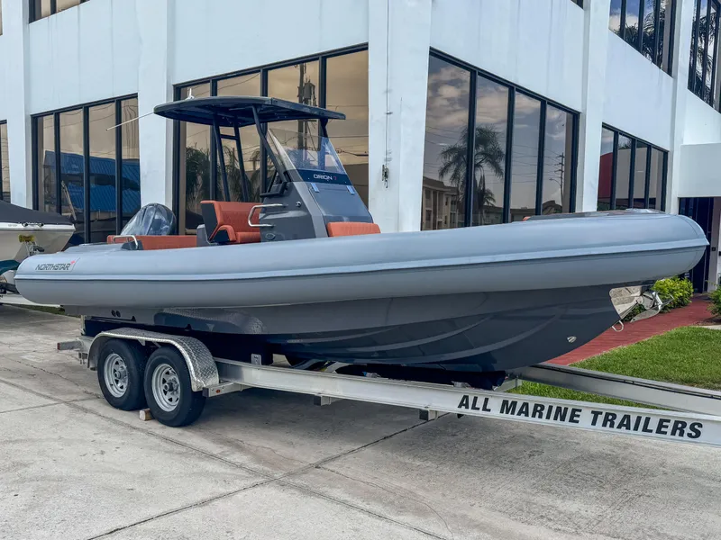 The Image of 2023 Northstar Orion 7 boat on trailer outside a modern building. - 0