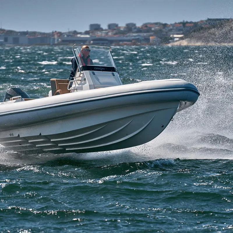 Slide: The Image of 2023 Northstar Orion 7 boat navigating choppy waters with cityscape in background. - 13