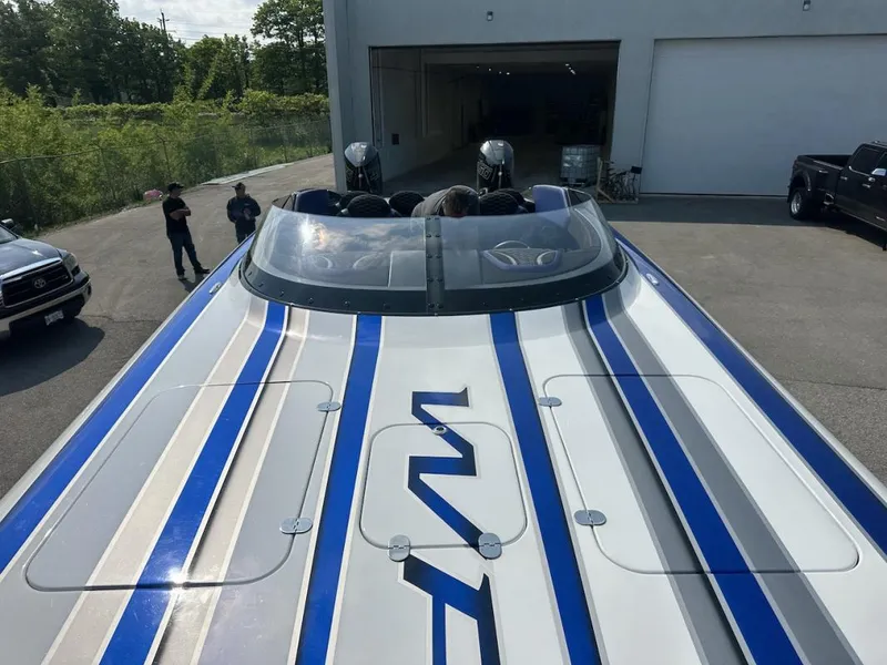 Slide: The Image of 2018 Wright Performance 420 boat with blue and gray stripes, parked outside a garage. - 28