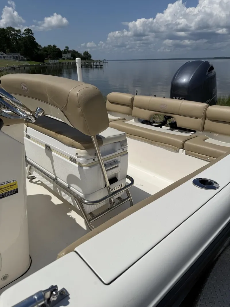 Slide: The Image of 2018 Key West 189 FS boat interior with beige seating, docked by a calm lake. - 3