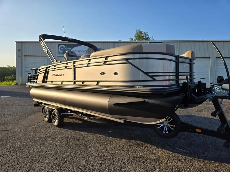 Slide: The Image of 2026 Starcraft EXS3DL pontoon boat on trailer, parked outside a building. - 5