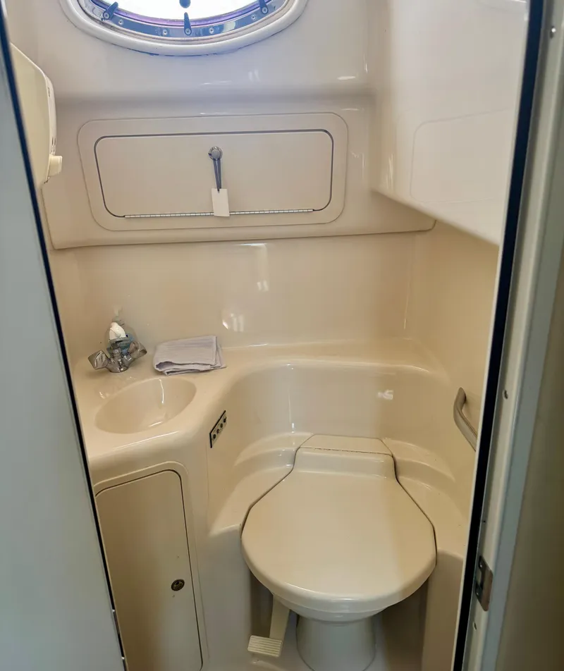 Slide: The Image of Bathroom interior of 1999 Sea Ray 400 Sundancer yacht, featuring compact toilet and sink. - 10