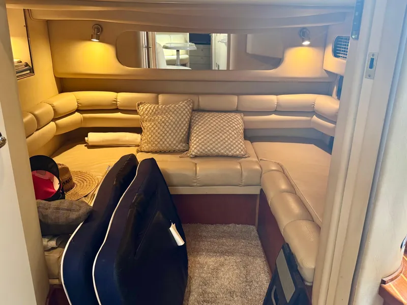 Slide: The Image of Interior of 1999 Sea Ray 400 Sundancer with beige seating and cozy decor. - 12