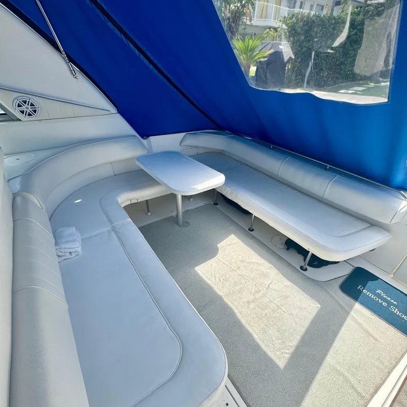 Slide: The Image of 1999 Sea Ray 400 Sundancer interior with blue canopy and white seating area. - 4