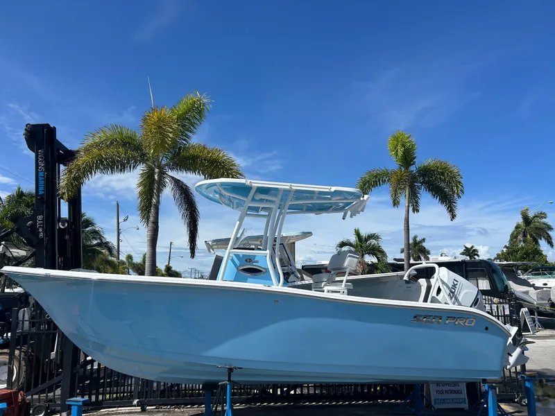 The Image of 2025 Sea Pro 225 Sandbar boat displayed outdoors with palm trees and blue sky. - 0