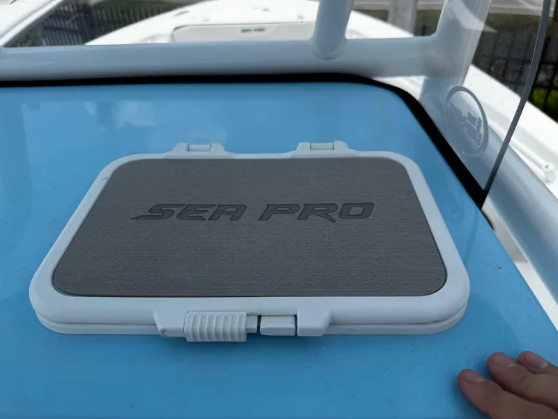 Slide: The Image of 2025 Sea Pro 225 Sandbar boat hatch with logo on a blue surface. - 11