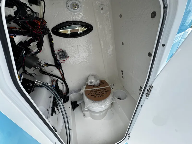 Slide: The Image of Interior of 2025 Sea Pro 225 Sandbar boat, featuring a compact marine toilet. - 17