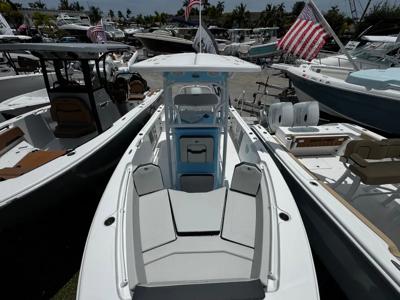 Slide: The Image of 2025 Sea Pro 225 Sandbar boat displayed at a marina with American flags. - 36