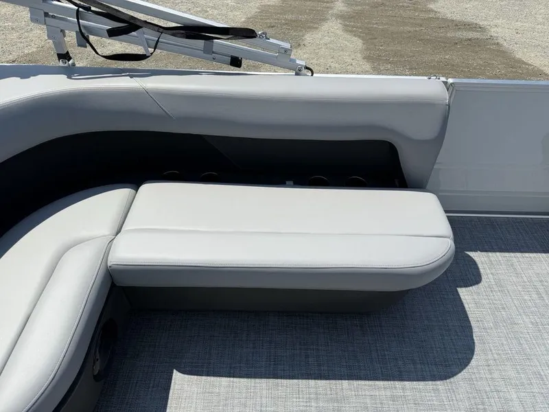 Slide: The Image of 2026 Sun Tracker PARTY BARGE® 16 DLX interior seating with gray upholstery and cup holders. - 16