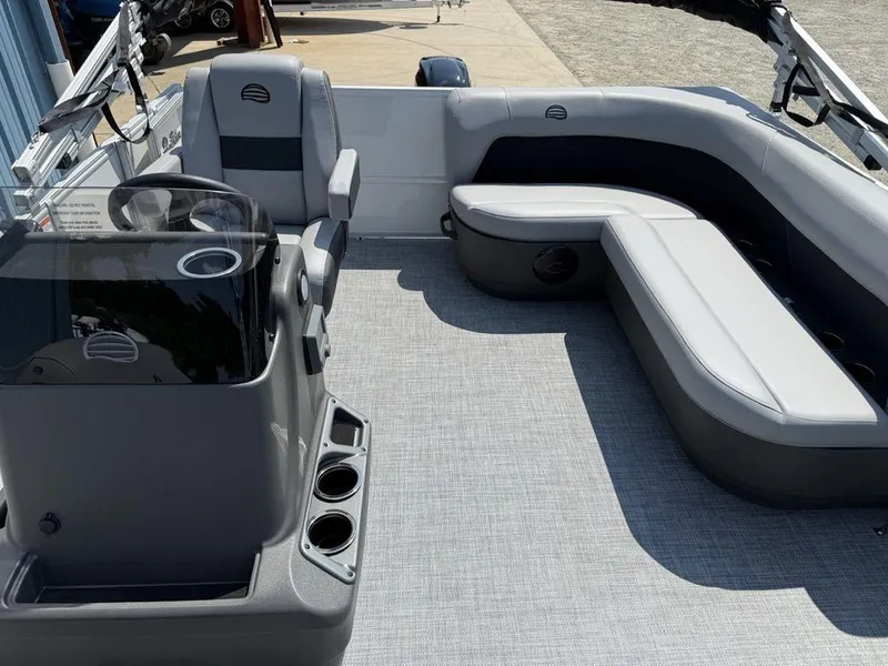 Slide: The Image of 2026 Sun Tracker PARTY BARGE® 16 DLX interior with gray seating and steering console. - 18