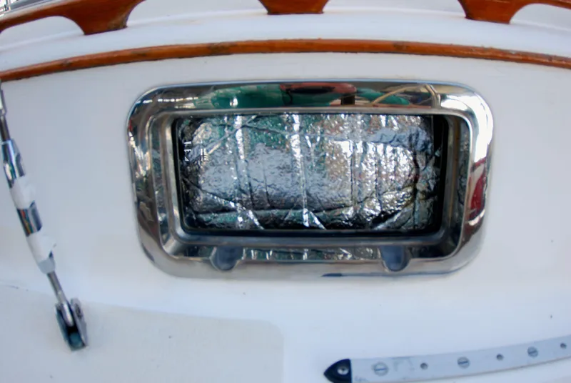 Slide: The Image of 1985 Endeavour 38 boat window with reflective insulation and wooden trim. - 10