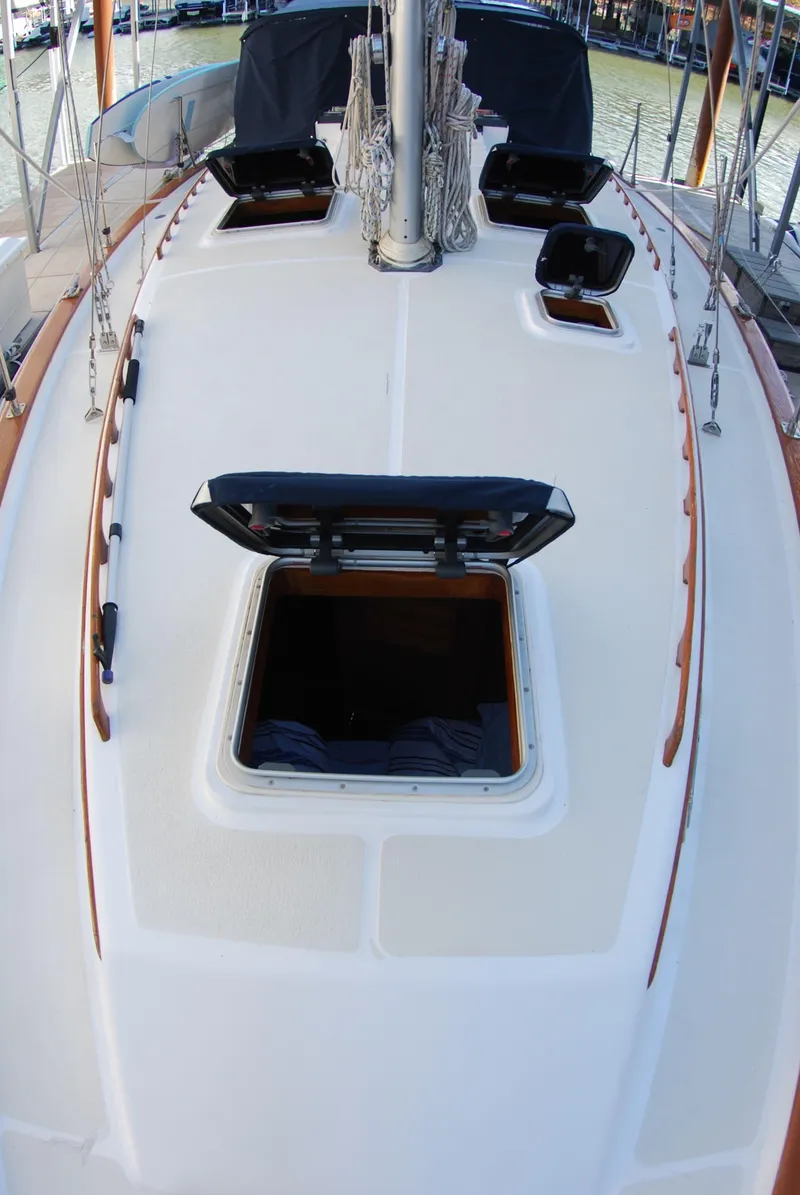 Slide: The Image of 1985 Endeavour 38 sailboat deck with open hatches, showcasing clean design and wood accents. - 12