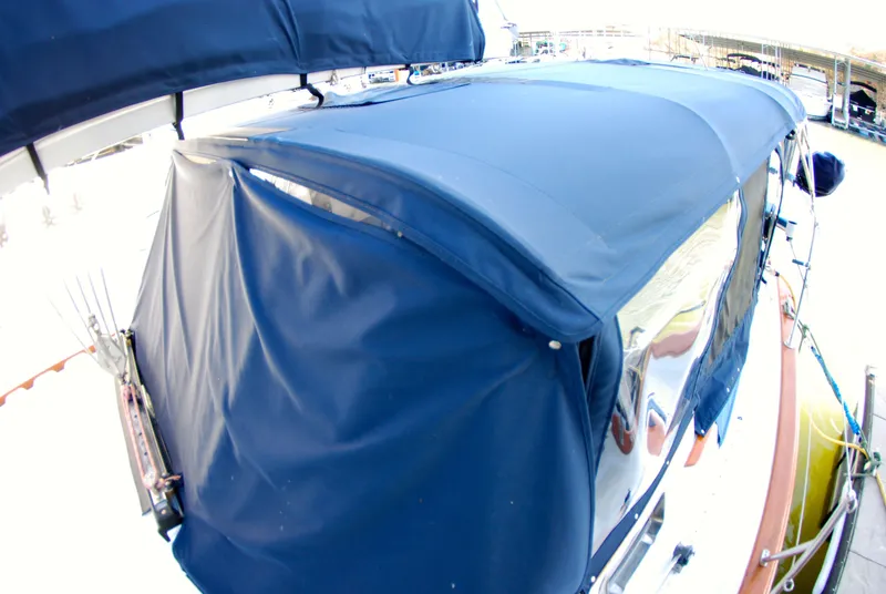 Slide: The Image of 1985 Endeavour 38 sailboat with blue canvas cover docked at marina. - 16