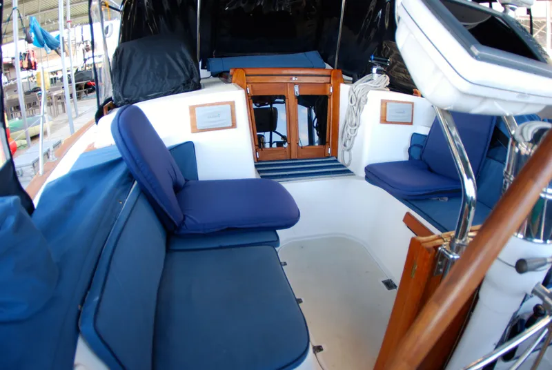 Slide: The Image of Cockpit of 1985 Endeavour 38 sailboat with blue cushions and wooden accents. - 25