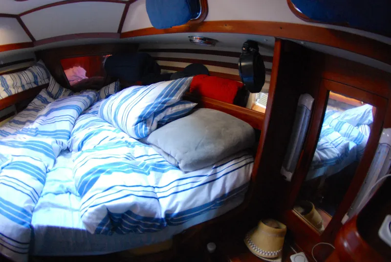 Slide: The Image of Cozy cabin interior of 1985 Endeavour 38 sailboat with striped bedding and wooden accents. - 29