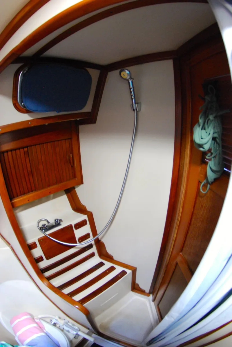 Slide: The Image of Compact shower area in 1985 Endeavour 38 sailboat with wooden accents and handheld showerhead. - 36