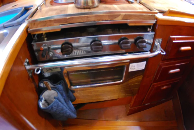 Slide: The Image of Galley kitchen in 1985 Endeavour 38 sailboat with stove and wooden cabinetry. - 38